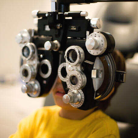 Preschool boy having an eye exam. Natural dim light.